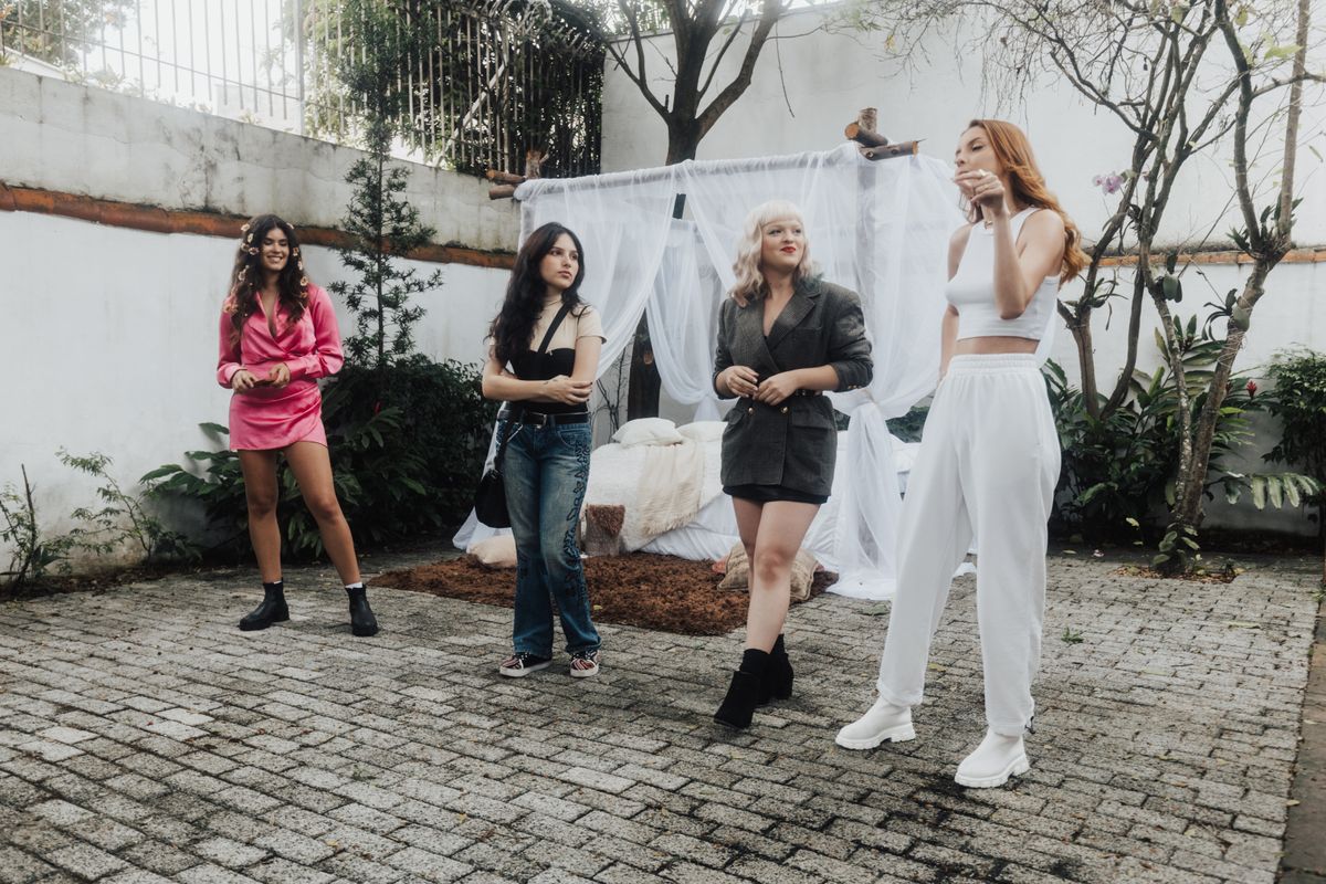 A diverse group of women models posing outdoors in stylish outfits, showcasing fashion trends.